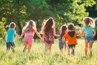 Rennende Kinder auf einer Wiese.